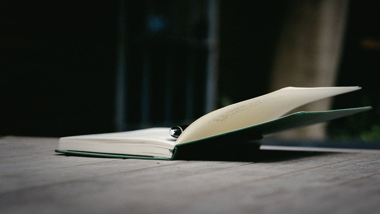 An open notebook and pen on a wooden table