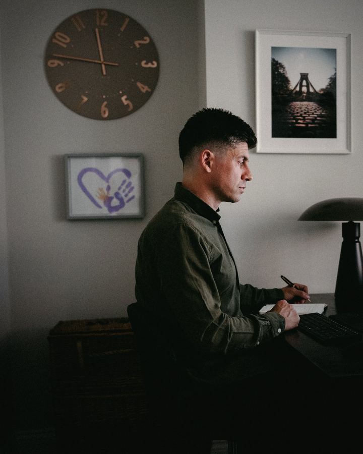 Siôn working at his desk, in profile